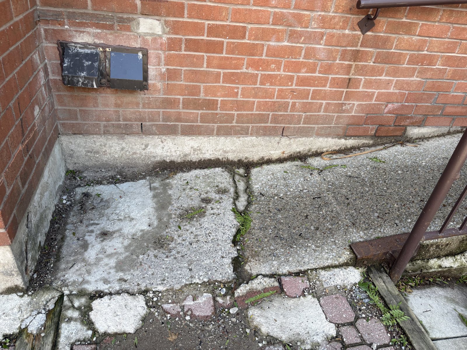 A Toronto commercial entrance with spalled, salt-eaten concrete at the corner