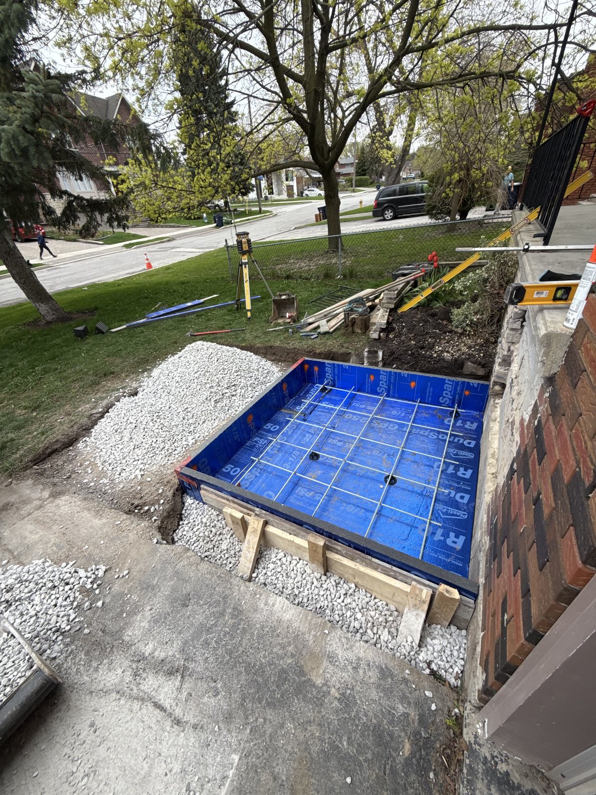 Formwork with rigid insulation and a tied rebar mat prepared over a compacted stone base