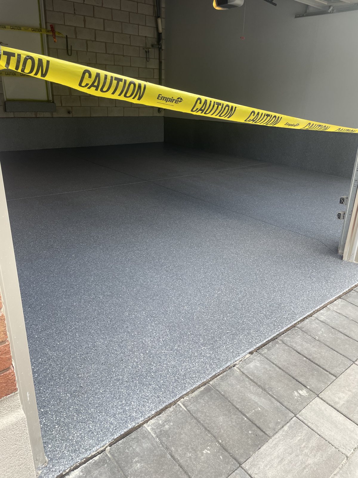 The coated garage floor meeting the interlock driveway on a clean line