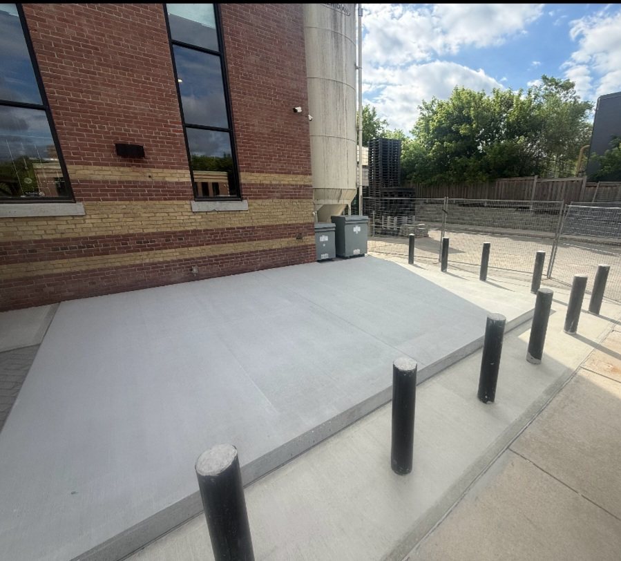 A finished concrete pad with steel bollards set along its edge