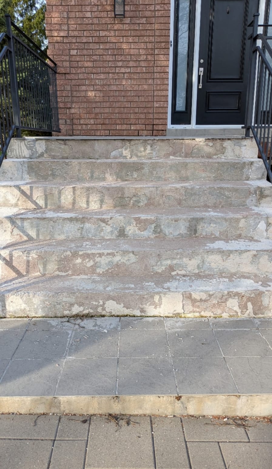 Painted concrete steps with the paint peeling and the surface spalling beneath