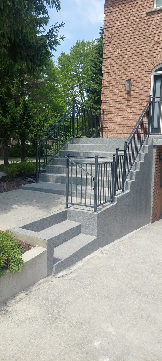 After — Concrete porch step resurfacing in North York by Concrete Repair Plus. Rebuilt steps with non-slip flake finish and new modern railings.