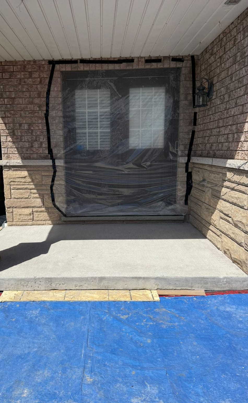 A crew member mechanically preparing a residential porch surface before coating